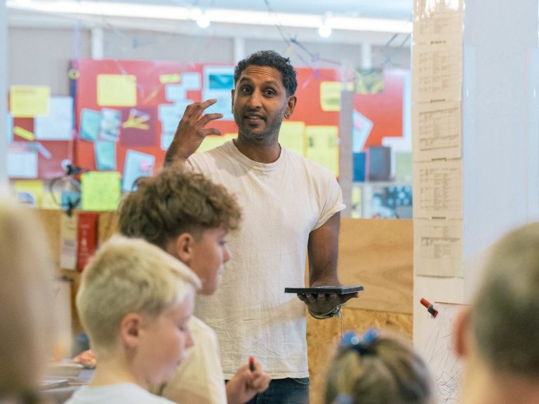 An artist working alongside children during an art session, illustrating CPD-supported creative education