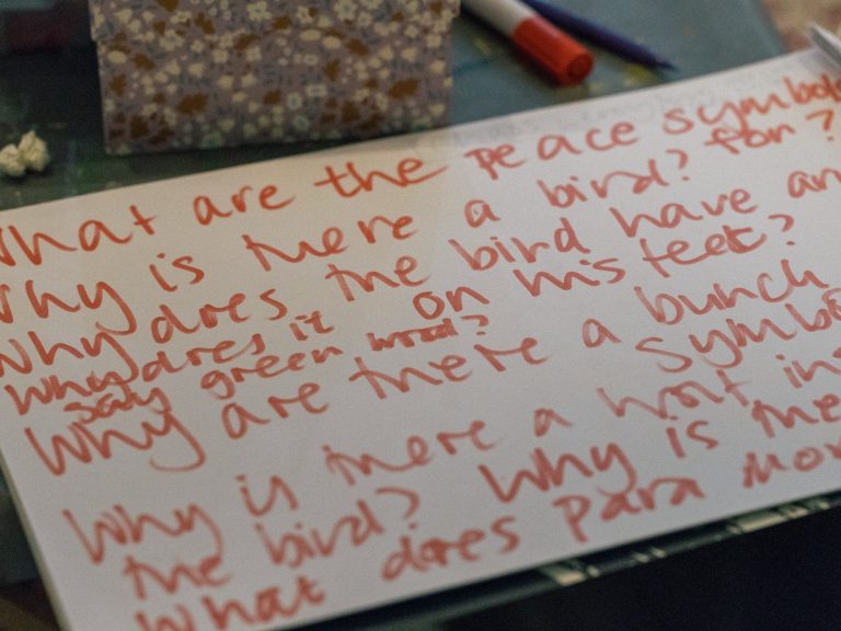 A close-up photo of orange writing on a piece of paper